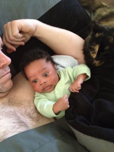 2010 Subaru Legacy - A baby is held by a person, with a cat also present in the scene.