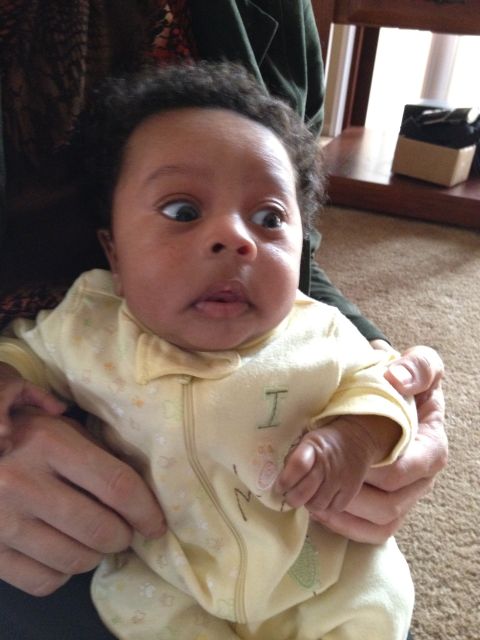 2010 Subaru Legacy - A baby with wide eyes looks to the side while being held.