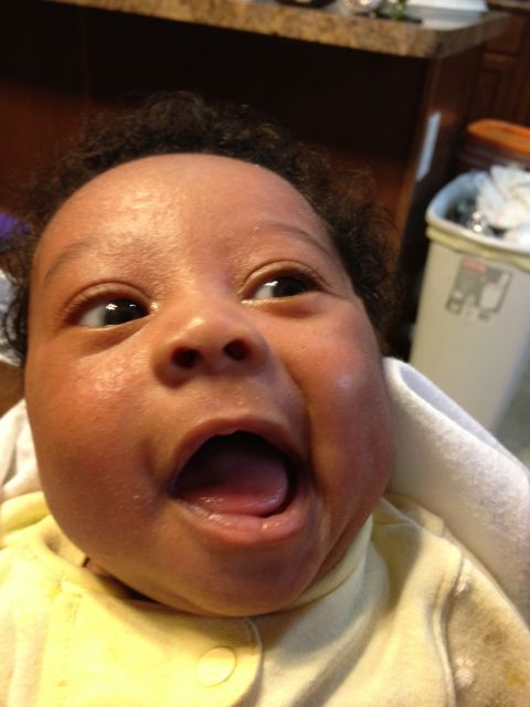 2010 Subaru Legacy - A baby's face is shown in a close-up shot, with its mouth open and eyes looking upwards.