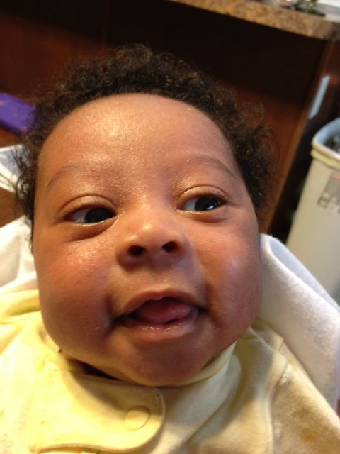 2010 Subaru Legacy - A baby's face is shown in a close-up, with their eyes looking to the right and their tongue sticking out slightly.
