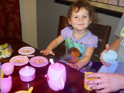 1976 Ford Bronco - A young child is playing with a pink toy tea set at a wooden table.