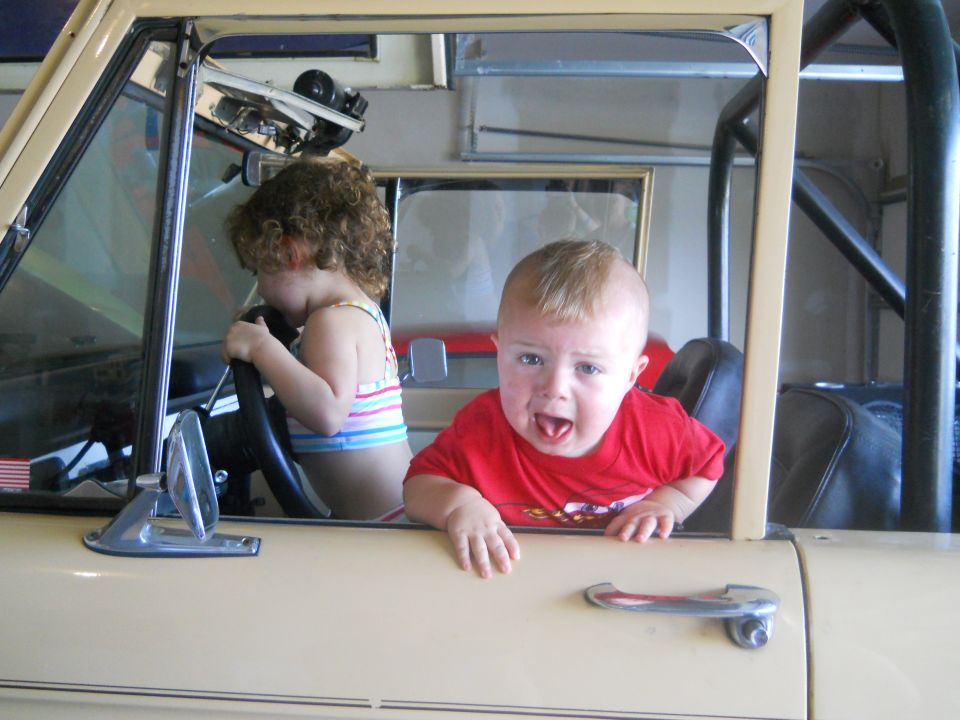Kid in driver's seat, another kid in passenger seat, both looking out