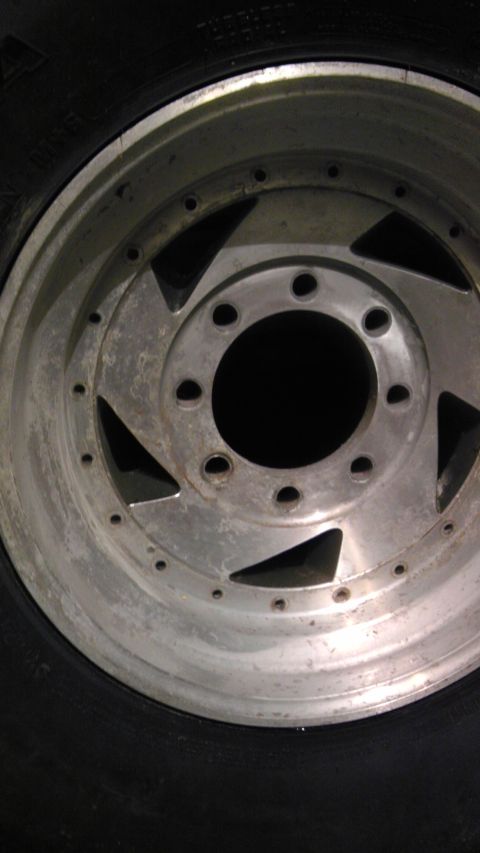 1989 Ford Bronco - A close-up view of a silver alloy wheel and tire.