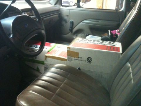 1992 Ford Bronco - Boxes fill the passenger seat and floor of a truck's interior, obscuring the view of the dashboard and seats.