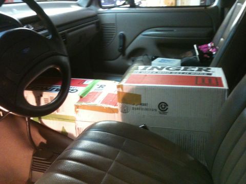 1992 Ford Bronco - Boxes are loaded into the passenger side of a vehicle, obscuring the view of the interior details.