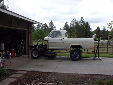 1967 Ford F-250 - A white 1967 Ford F-250 pickup truck is shown in a driveway, appearing to be in the process of repair or restoration.