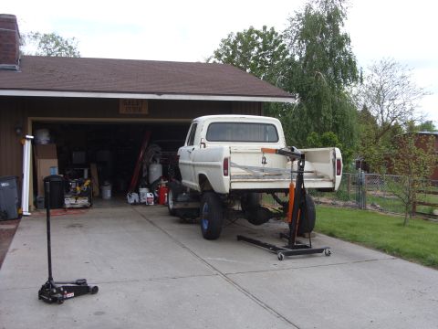 1967 Ford F-250 - White 1967 Ford F-250 pickup truck in driveway with rear axle removed for maintenance.