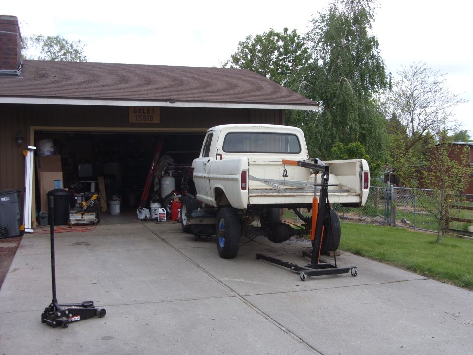 1967 Ford F-250 pickup truck with tailgate down, rear axle removed, in driveway