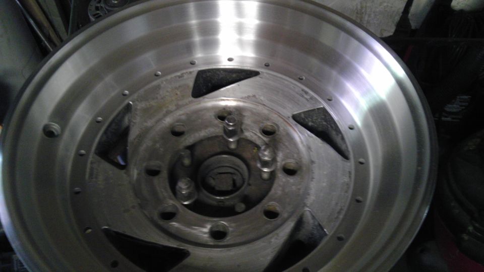 Close-up of an aftermarket aluminum wheel with a five-spoke design and a polished lip