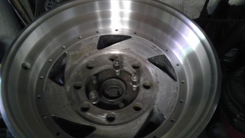 1989 Ford Bronco - This is a close-up view of an aftermarket aluminum wheel, showing its lug nut holes and distinctive design elements.