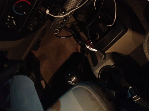 2005 Jeep Wrangler - The interior of a vehicle is shown, focusing on the hand throttle and gear shift mechanism.