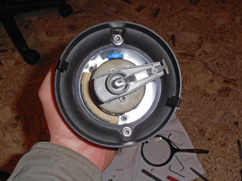 1990 Ford Bronco - A person holds a vehicle's distributor cap and rotor assembly, showing internal components.