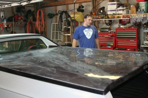 1976 Ford Ranchero - A person stands in a garage next to a white vehicle with its bed cover visible.