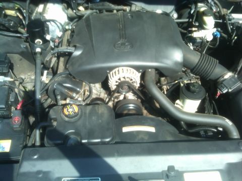 1999 Ford Crown Victoria - Close-up view of a vehicle's engine bay, showing various components and the Ford logo.
