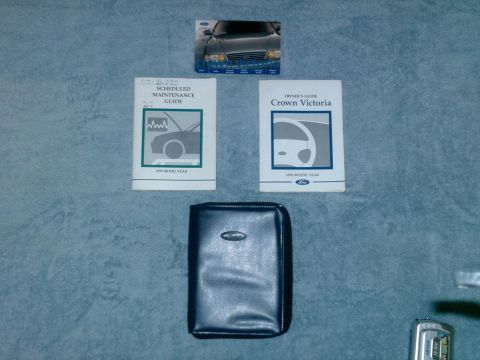 1999 Ford Crown Victoria - Owner's manual and maintenance guide for a 1999 Ford Crown Victoria are laid out on a textured surface.