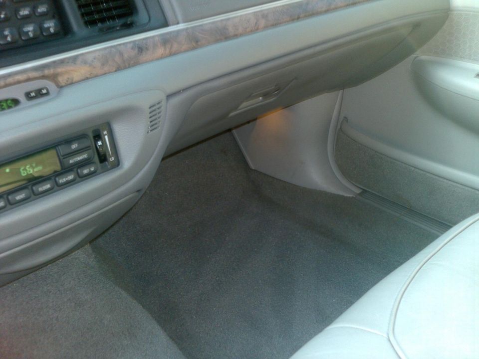 Interior shot of a 1999 Ford Crown Victoria showing the dashboard, radio, and floor