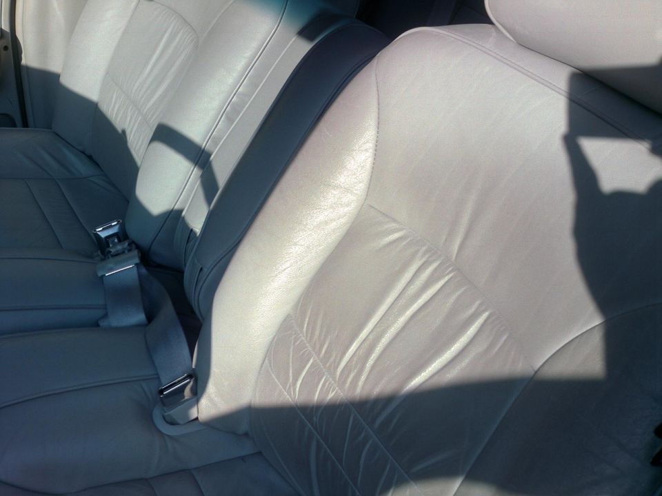 Light gray leather interior seats with seatbelts visible