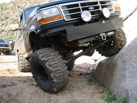 1994 Ford Bronco - A modified Ford Bronco navigates a rocky trail, with another truck visible in the background.
