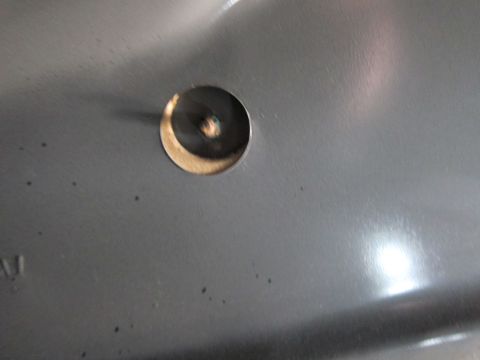 1991 Ford LTD Crown Victoria - A close-up view of a gray metal panel with a hole and a screw head is shown.