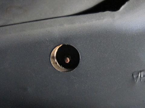 1991 Ford LTD Crown Victoria - Detail of a hole and screw on a dark car interior panel.