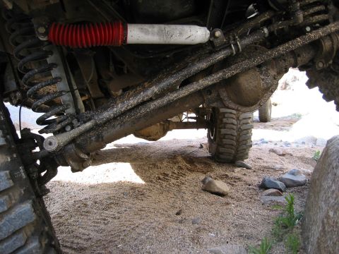1994 Ford Bronco - Close-up view of the undercarriage of a 4x4 vehicle, highlighting its suspension and drivetrain components.