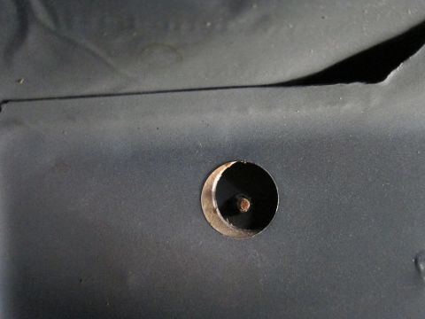 1991 Ford LTD Crown Victoria - A close-up view shows a bolt protruding through a circular opening in a dark gray metal surface.