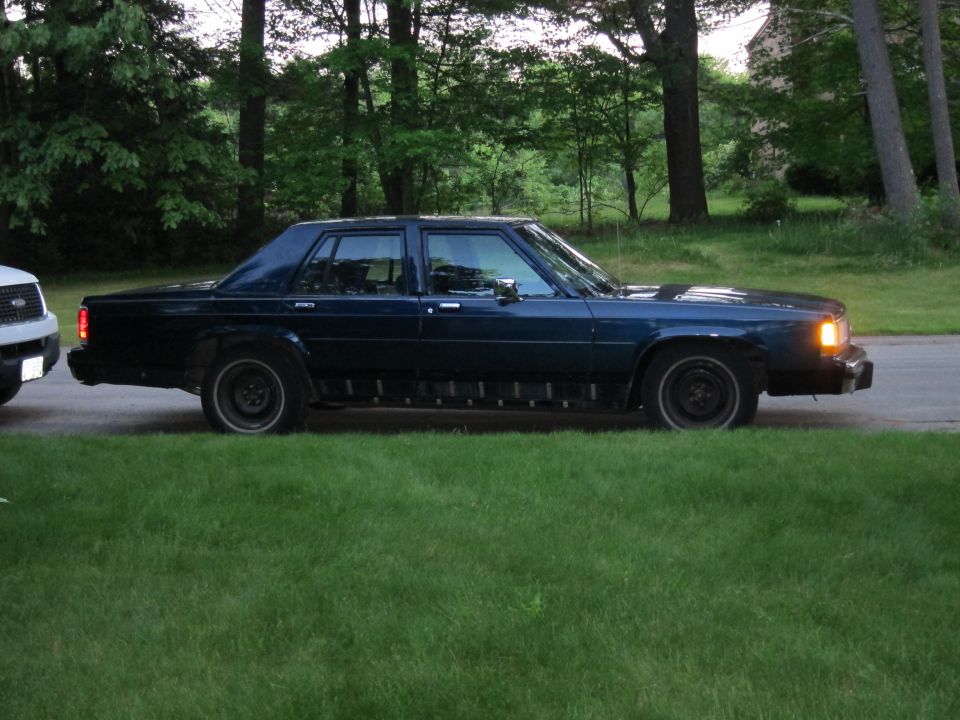 Side view of a dark blue 1991 Ford Crown Victoria LTD parked on grass