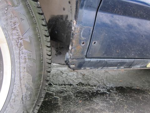 1991 Ford LTD Crown Victoria - Rust is visible on the lower body panel and wheel well of a car.