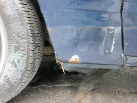 1991 Ford LTD Crown Victoria - Side view of a blue 1991 Ford Crown Victoria LTD with visible rust damage.