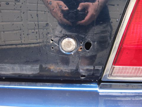1991 Ford LTD Crown Victoria - Close-up of the rear of a dark blue vehicle, showing a keyhole and part of a red taillight.
