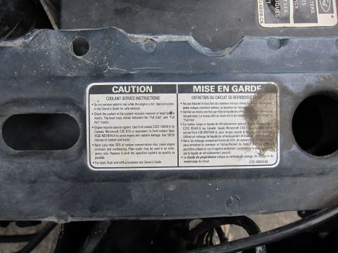 1991 Ford LTD Crown Victoria - Underhood caution label giving coolant service instructions in English and French (Mise en Garde).