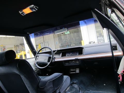 1991 Ford LTD Crown Victoria - Interior view of a sedan, likely from the early 1990s, with a dark blue velour interior and wood trim on the dashboard.