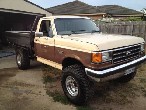1987 Ford F-250 - This 1987 Ford F-250 pickup truck features a two-tone brown and tan paint scheme and a functional flatbed.