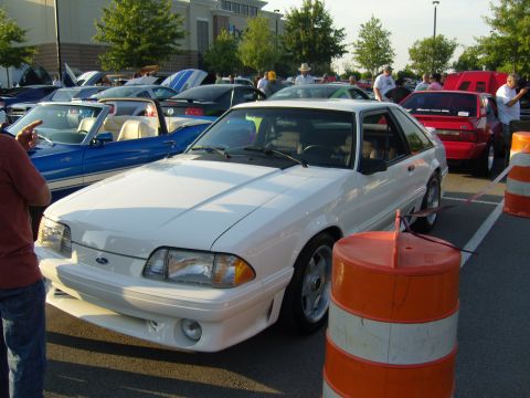 2007 Ford Mustang - A white Fox body Mustang is parked at an outdoor car show with other vehicles visible.