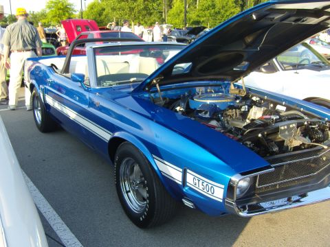 2007 Ford Mustang - A blue 1969 Ford Mustang convertible with its hood open is parked at an outdoor event.