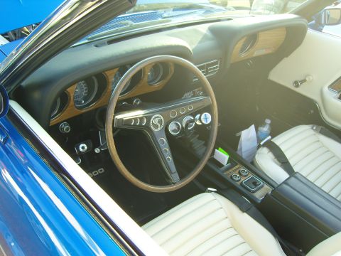 2007 Ford Mustang - Interior view of a 1969 Ford Mustang convertible, a wood-grain dashboard and a Shelby Cobra steering wheel.