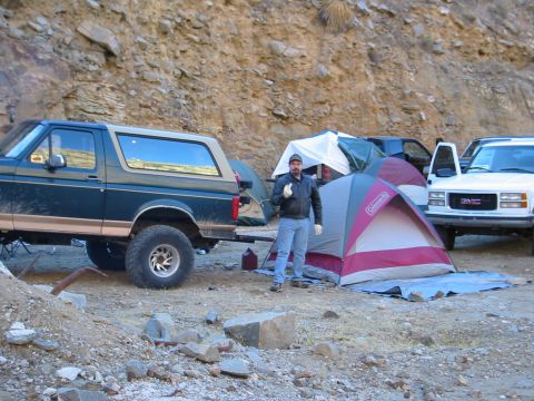 1994 Ford Bronco - A Ford Bronco and other vehicles are parked at a campsite with tents set up in a rocky, mountainous area.