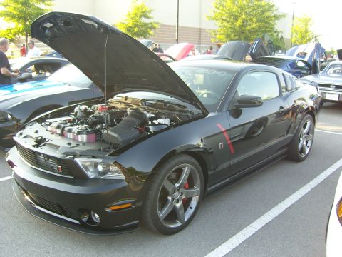 2007 Ford Mustang - A black Ford Mustang is parked with its hood open, revealing the engine compartment.