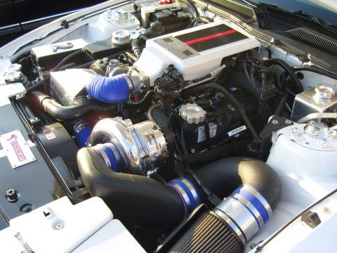 2007 Ford Mustang - Engine bay features a prominent supercharger and Shelby branding.