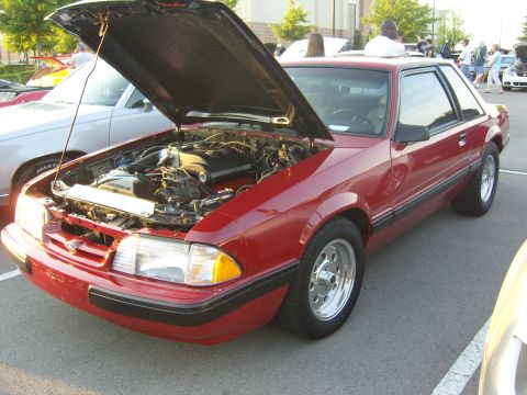 2007 Ford Mustang - This red coupe, likely a 1987 Ford Mustang, is shown with its hood open, revealing the engine compartment.