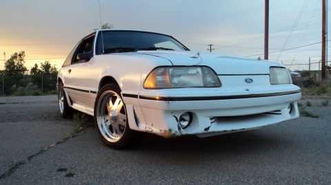 1989 Ford Mustang - Front view of a white 1989 Ford Mustang with custom wheels and some front bumper damage.