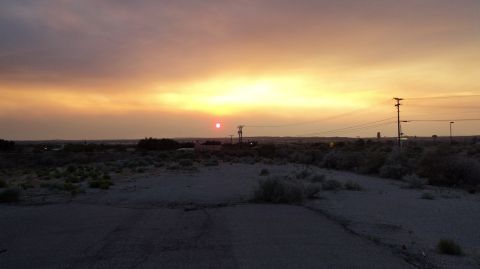 1989 Ford Mustang - The sun sets over a desolate landscape, casting a warm glow across the sky.