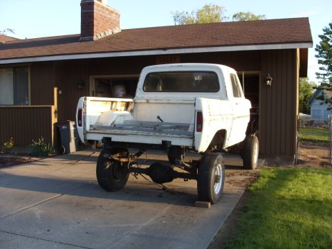1967 Ford F-250 - Rear view of a white 1967 Ford F-250 pickup truck with a modified suspension and missing bed components.