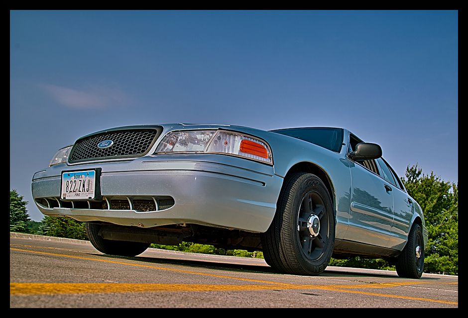Low-angle front view of silver Ford Crown Victoria with black steel wheels and Iowa plate 822 ZKJ