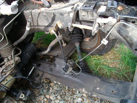 1989 Ford Probe - Close-up view of a vehicle's front suspension and steering system, showing mechanical components.