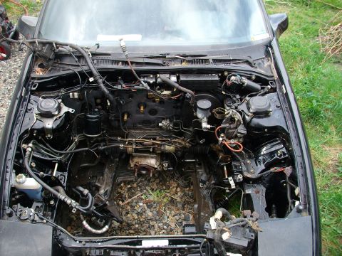 1989 Ford Probe - The engine bay of a vehicle is shown with the engine removed, revealing the internal components and wiring harness.