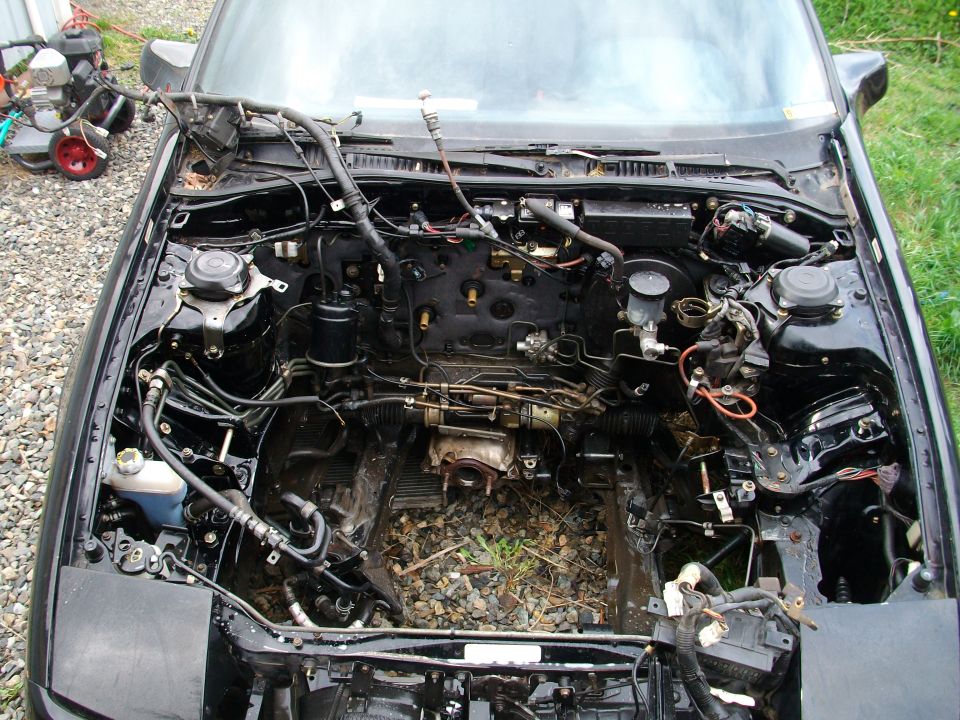 1989 Ford Probe engine bay with engine removed, showing wiring and components