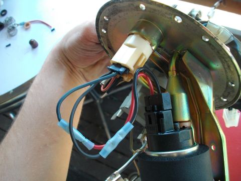 1989 Ford Probe - Close-up of a fuel pump assembly with electrical connections being handled.