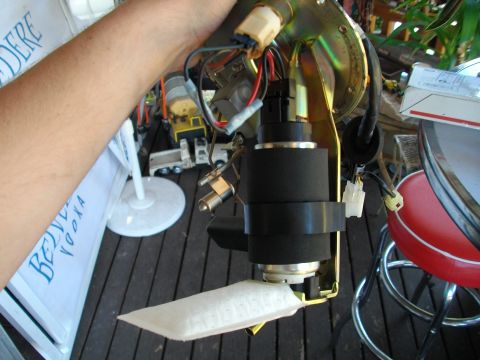 1989 Ford Probe - A person holds a fuel pump assembly, which includes a black filter and various electrical connectors.