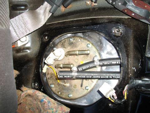 1989 Ford Probe - Close-up view of a vehicle's fuel pump assembly, revealing hoses and electrical connections.